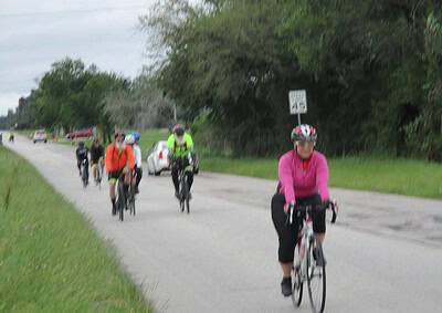 Bike touring along scenic roadside with Bluebonnet Express, featuring cyclists enjoying outdoor adventure.