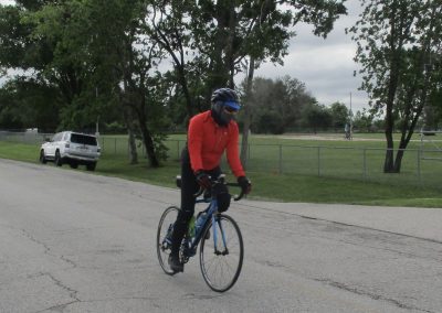 Versatile cyclist enjoying a ride on a quiet park road, emphasizing recreational biking with Bluebonnet Express.