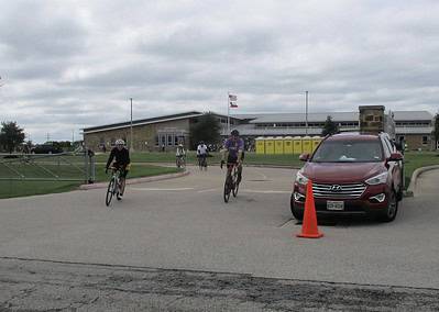 Bicycle riders during Bluebonnet Express event at Le Jone Elementary School, Texas, with a support vehicle nearby.