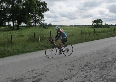 Scenic bike ride along rural country road with cyclist enjoying outdoor activity and fresh air.