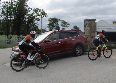 Vibrant cyclists riding in a group during daytime near Herman T. Jones Elementary School, showcasing Bluebonnet Express bike tour.