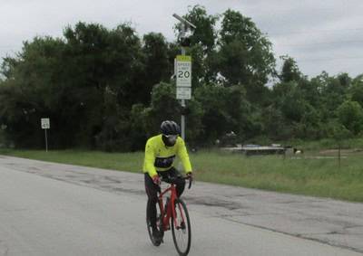 Bright yellow cycling jersey and red bike on the Bluebonnet Express route during daytime.