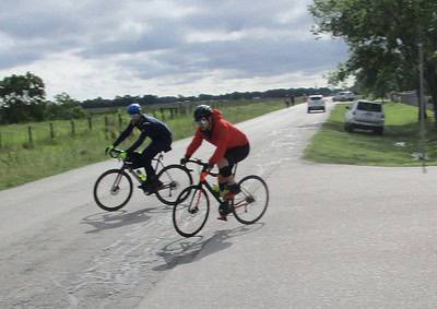 Bicycle riders on a rural road enjoying outdoor cycling adventure.