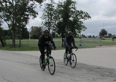 Bicycle riders enjoying a scenic ride in a park during cloudy weather.