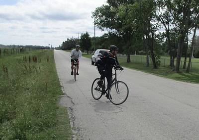 Cyclists riding on a rural road during daytime, promoting Bluebonnet Express bike tours and scenic Texas cycling routes.
