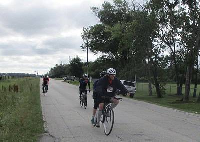 Bicycle riders participating in the Bluebonnet Express charity race on a rural road.