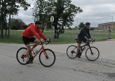 Bike riding on scenic trail during overcast day with Bluebonnet Express branding.
