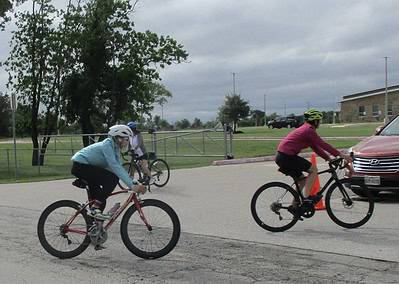 Cyclists riding on the street during a group bike ride event with Bluebonnet Express branding.