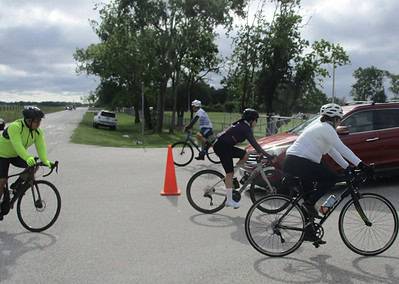 Cyclists riding in a charity or community bike event on a suburban road in Texas.