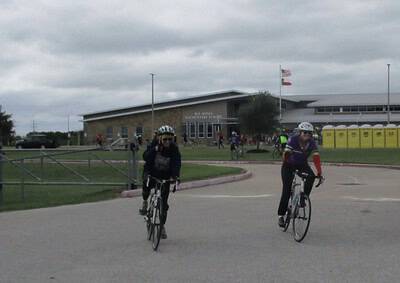 Riders cycling near Bluebonnet Elementary School during a community event in Texas.