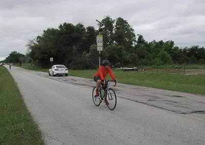 Cyclist on Bluebonnet Express bike route in Texas with scenic outdoor views and safety signs.