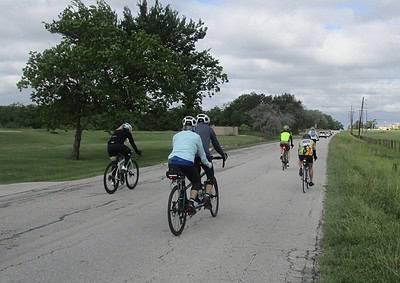 Bicycle group riding on scenic outdoor route, promoting cycling fitness and green transportation.