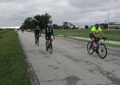Bike riders on a scenic outdoor trail in cloudy weather, promoting Bluebonnet Express cycling and Kansas bike routes.