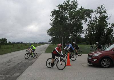 Bicycle riders participating in Bluebonnet Express event on a rural road.