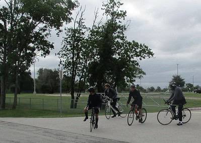 Bicycle riders with Bluebonnet Express bike trailer in park, outdoor cycling event.