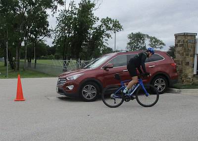 Bike rider on Bluebonnet Express with traffic cone and car, Texas bike and road safety.