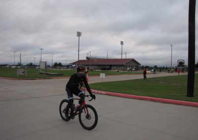 Bike rider at Bluebonnet Express stadium, outdoor cycling event on overcast day, showcasing active Texas sports scene.