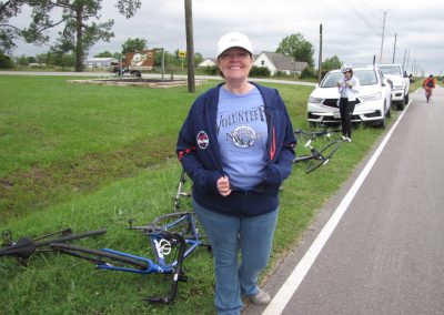 Volunteer woman with bike during Bluebonnet Express charity bike ride event outdoors.