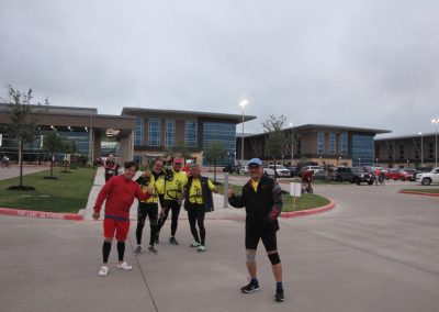 Bike riders at Bluebonnet Express event in front of modern building; cycling event, group ride, outdoor activity, Texas.