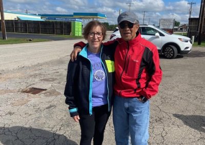 Elderly couple outdoors near Bluebonnet Express, enjoying a sunny day, perfect for biking and outdoor activities in Texas.