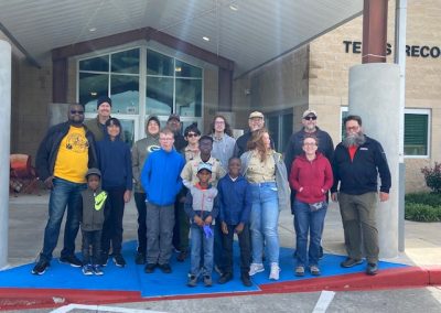 Group of diverse people at Bluebonnet Express bus service station, ready for a scenic Texas ride.