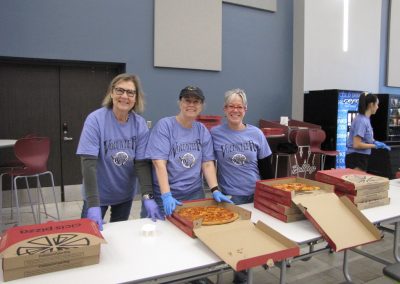 Support volunteers hand out pizza at Bluebonnet Express charity event.