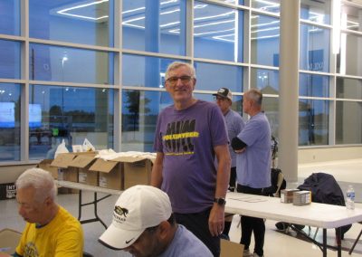 Volunteers at Bluebonnet Express event inside modern building, organizing supplies.