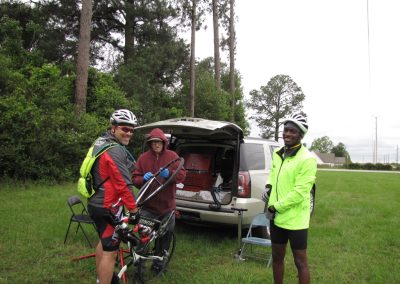 Cyclists preparing for Bluebonnet Express ride in lush outdoor setting.