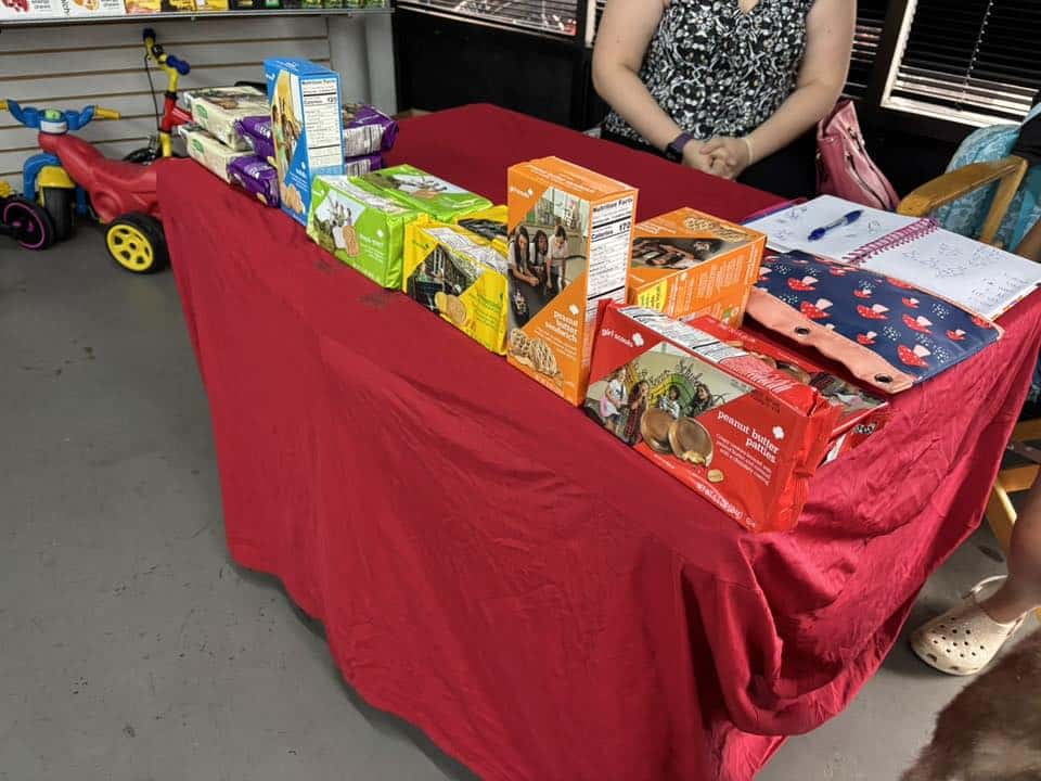 Colorful snacks and gift items displayed on a red table at Bluebonnet Express charity event.