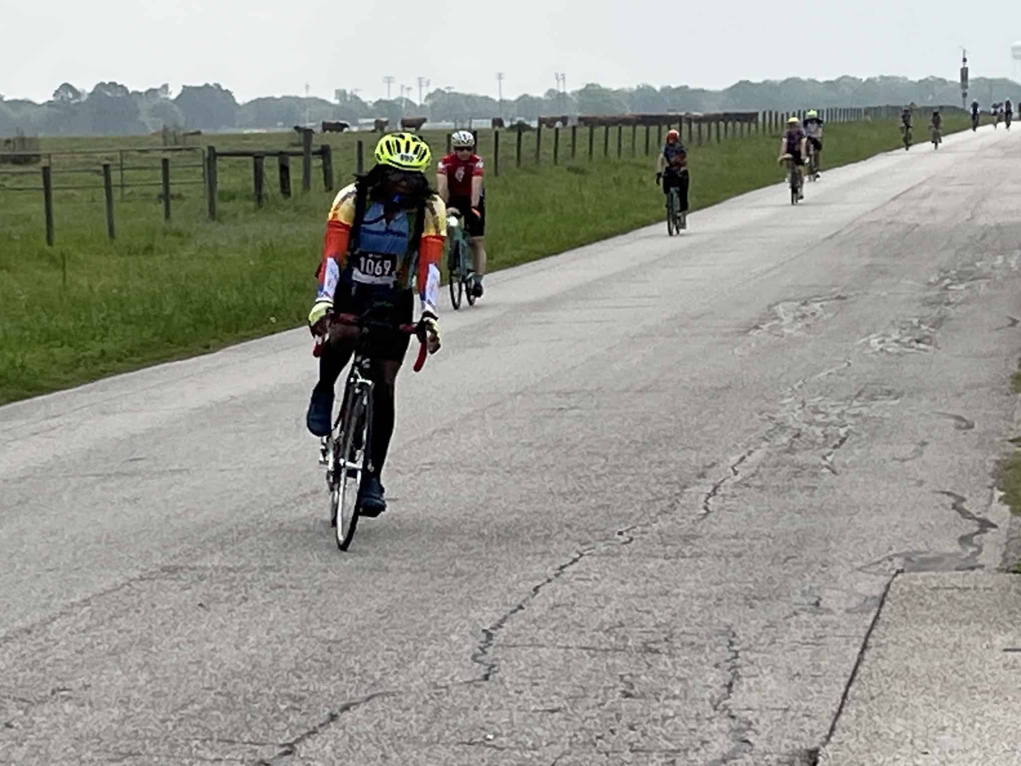 Cyclists riding along a scenic, open countryside road, promoting outdoor biking adventures for all.