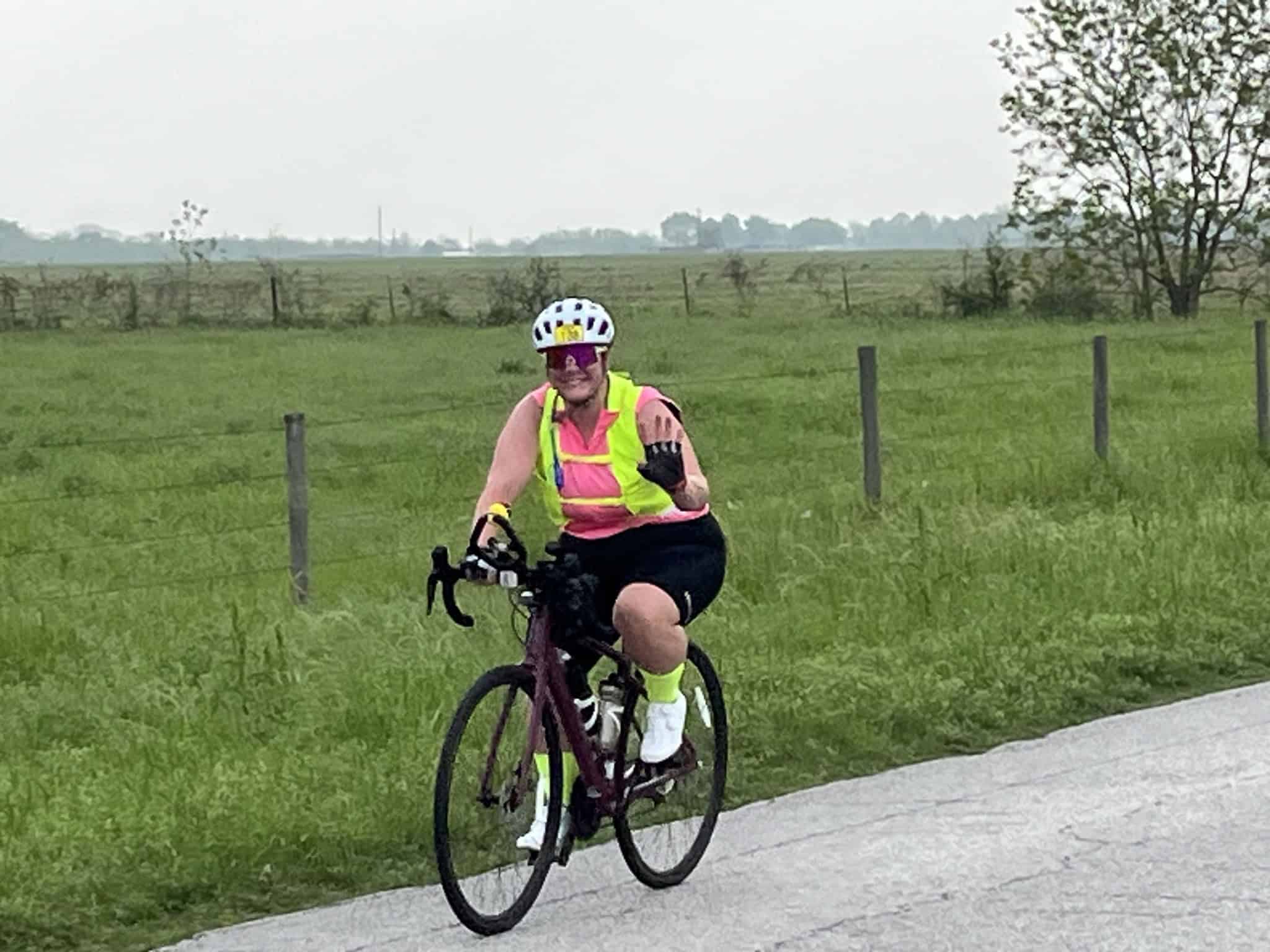Vibrant cyclist riding through scenic countryside on Bluebonnet Express bike trail in Texas.