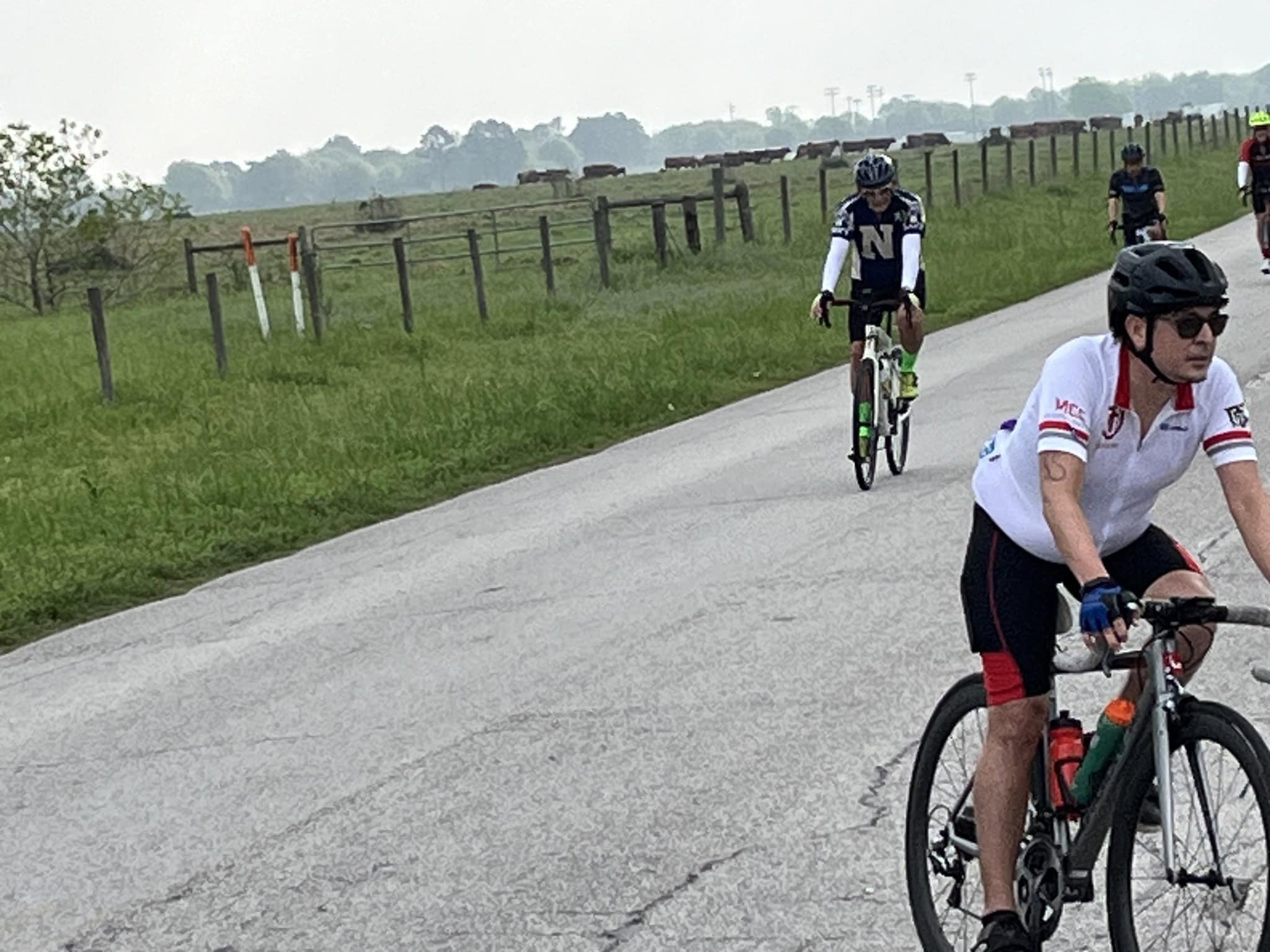 Cyclists riding on a scenic countryside road during daytime.