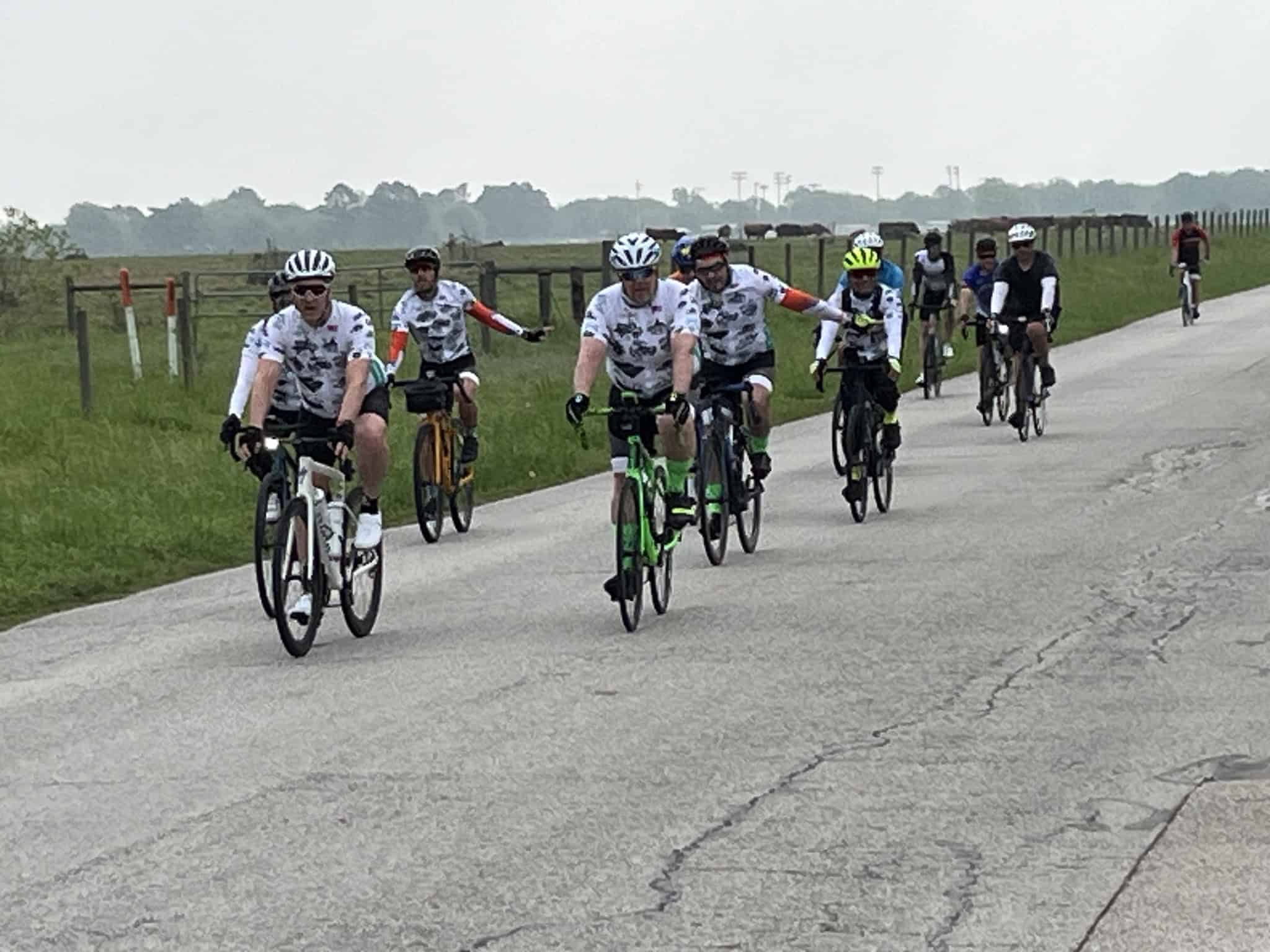 Cycling group on scenic rural road, children and adults riding bikes together.