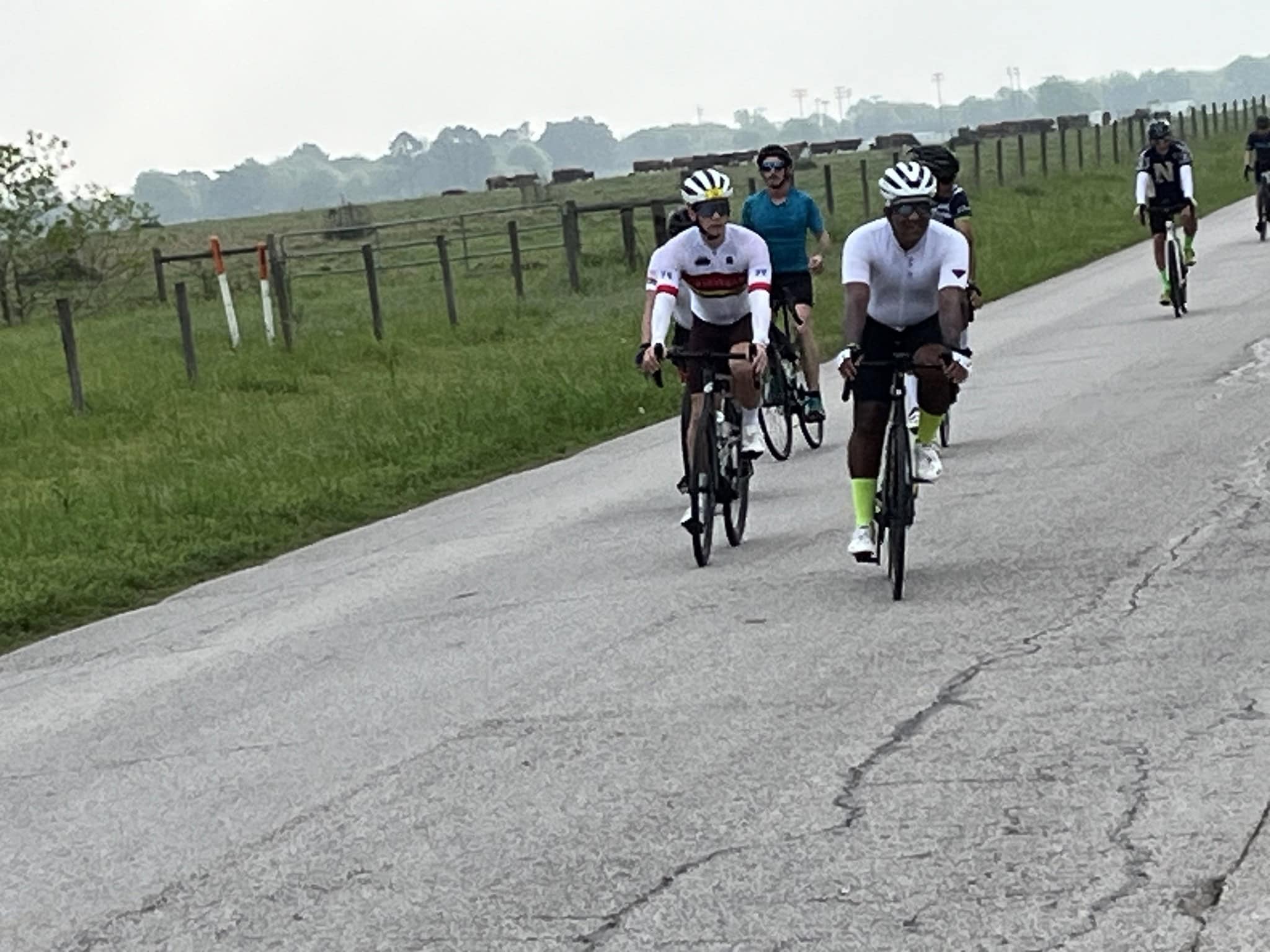 Cyclists riding on scenic rural road, part of Bluebonnet Express bike tour, enjoying outdoor sports and cycling adventure.