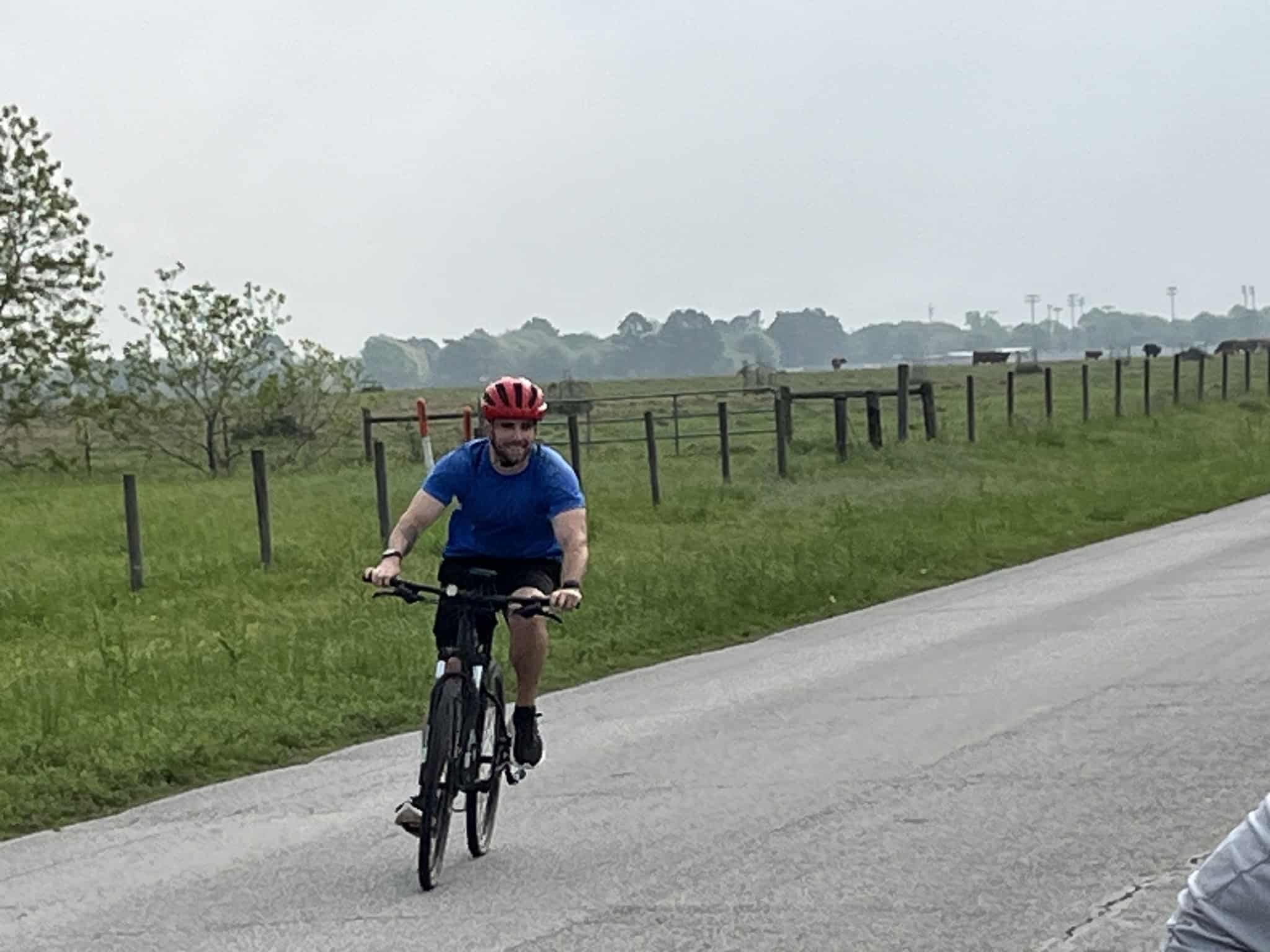 Vibrant cyclist riding through scenic rural landscape on Bluebonnet Express bike tour, enjoying the countryside.