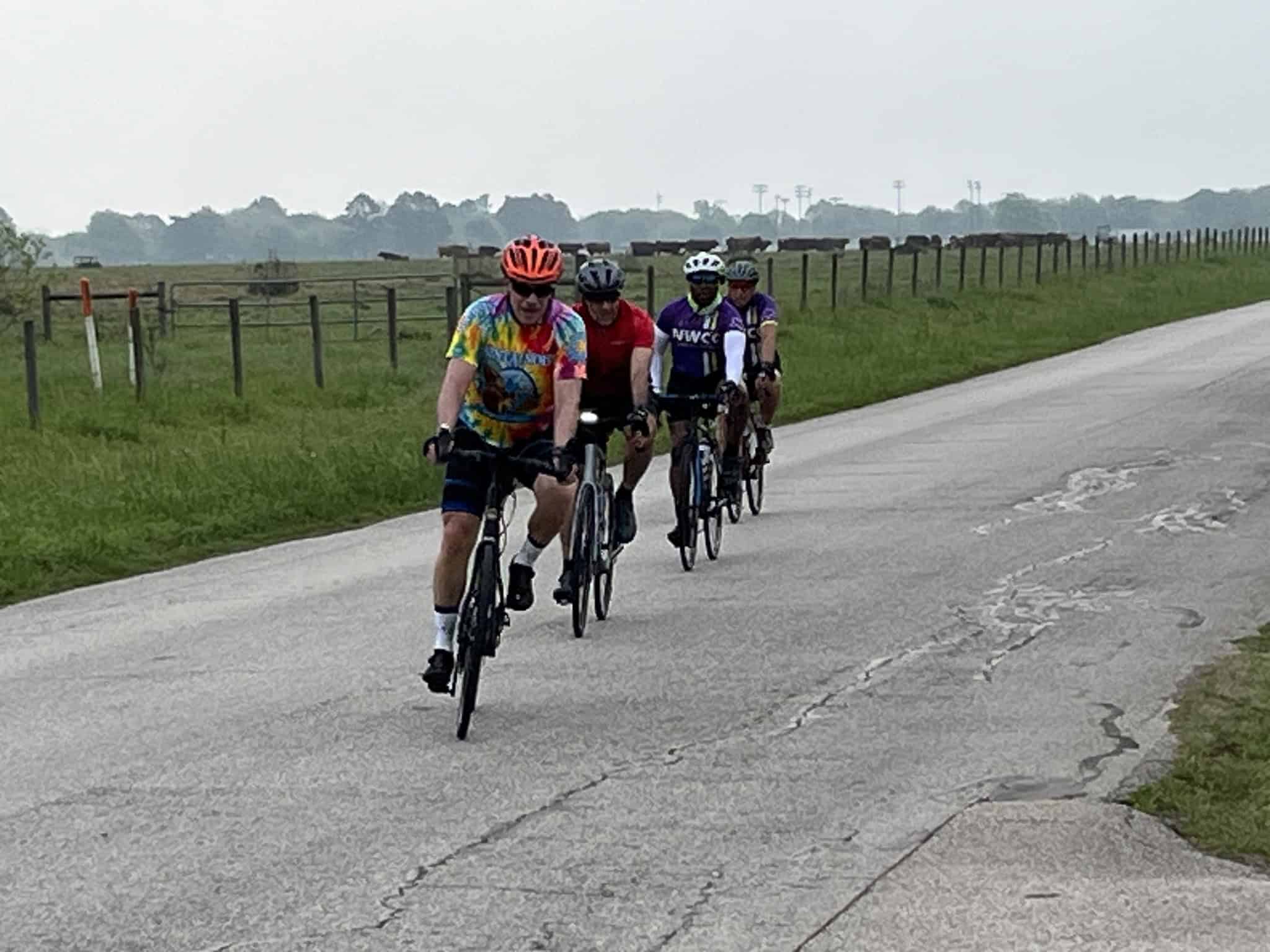 Cyclists riding along a scenic rural road on a family-friendly bike ride with Bluebonnet Express.