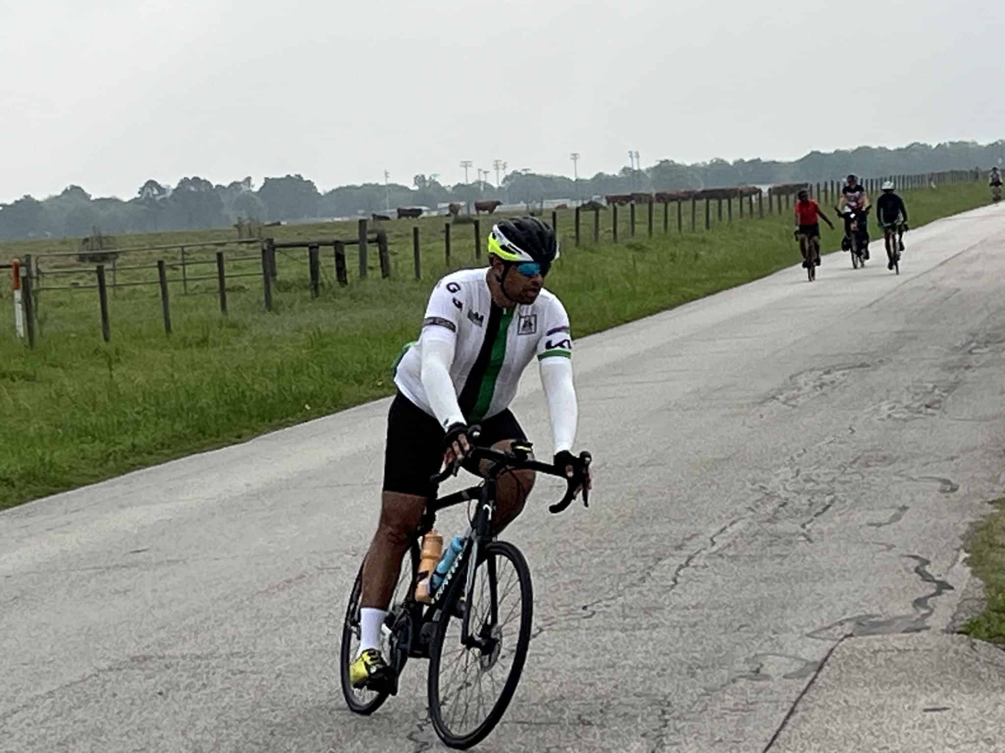 High-performance cyclist riding on open rural road during daytime.