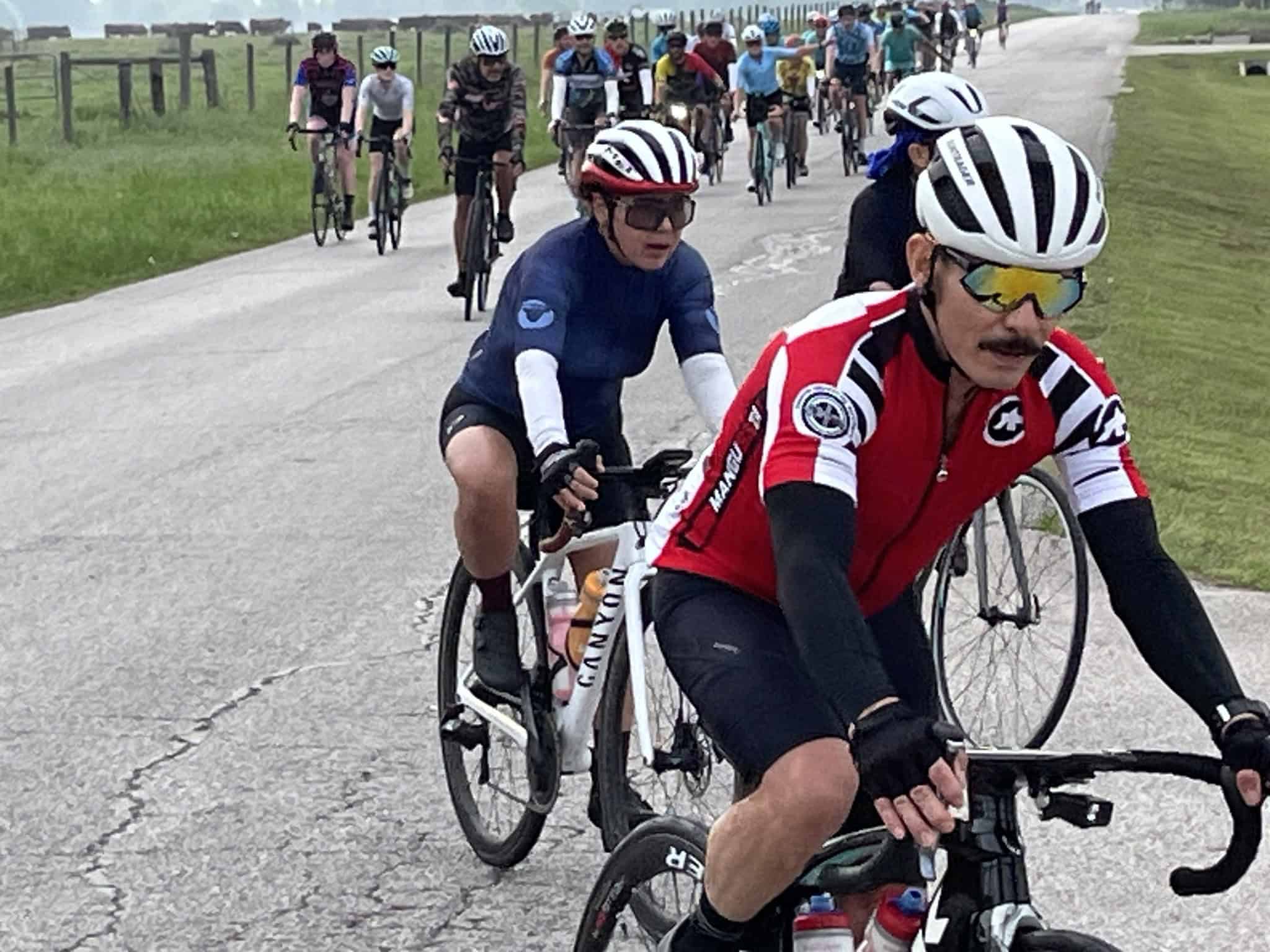 Brightly colored cyclist jerseys during a Bluebonnet Express charity ride on a rural Texas road.