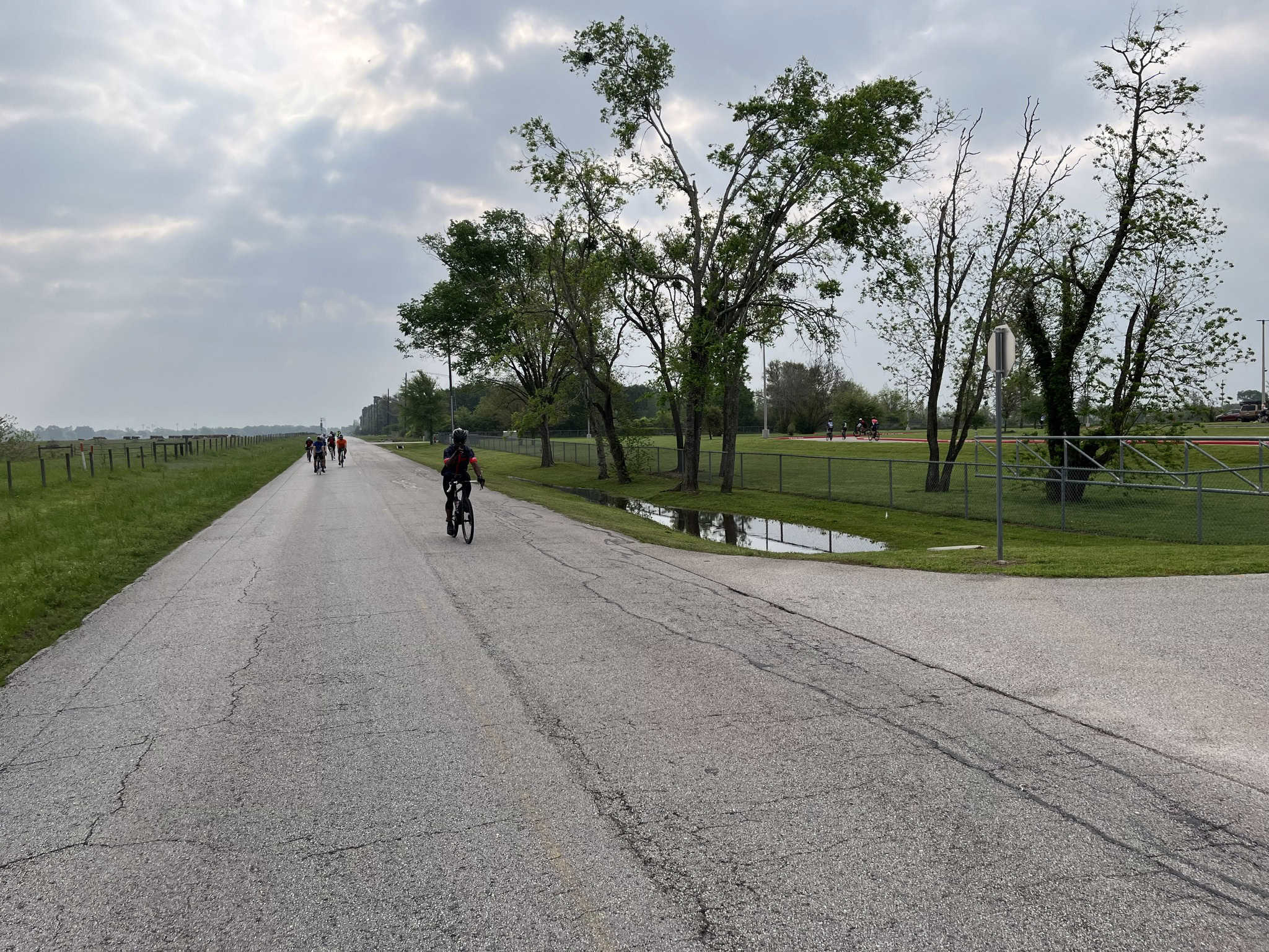 Open road biking scene with cyclists enjoying a scenic ride on a cloudy day.