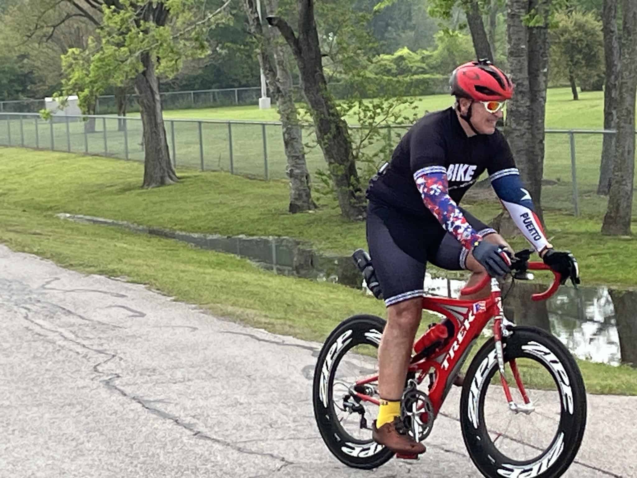 Bright red Trek bike on scenic park trail, cyclist wearing colorful cycling outfit.