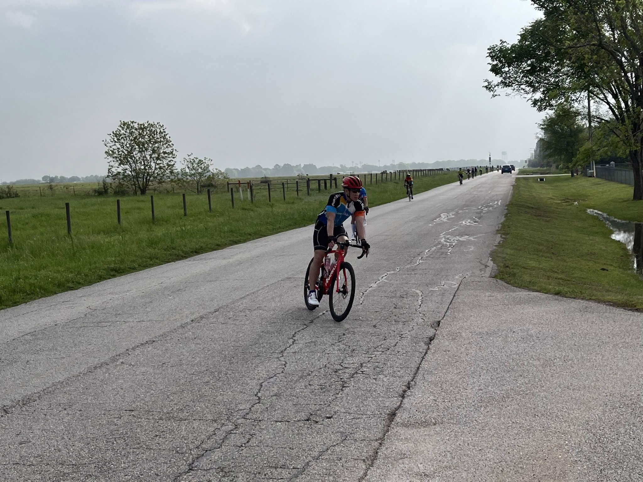 Bike riding along Bluebonnet Express scenic outdoor trail under cloudy sky, featuring cyclists enjoying a leisurely ride.