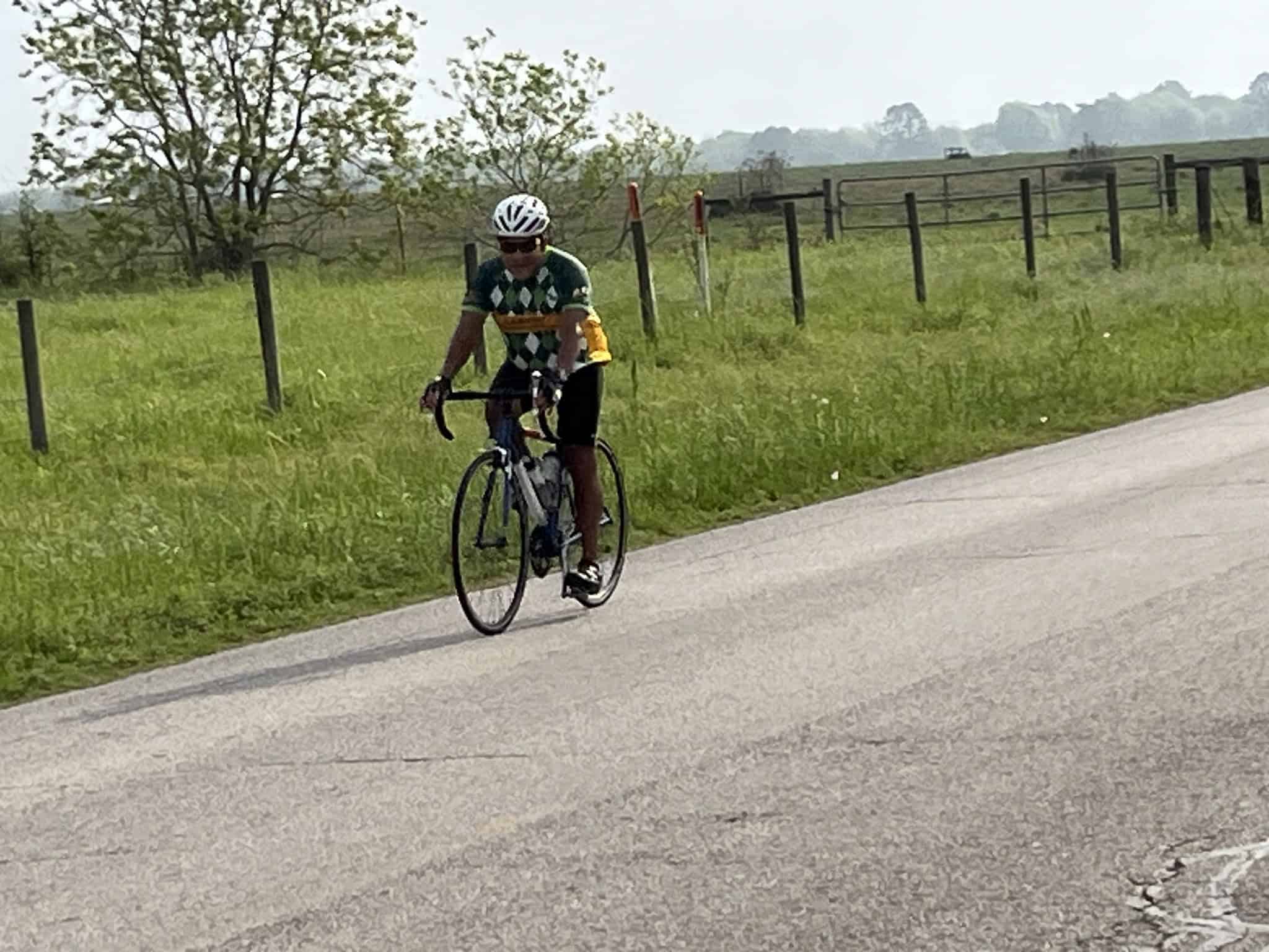 Cyclist riding on rural road in Texas during daytime.