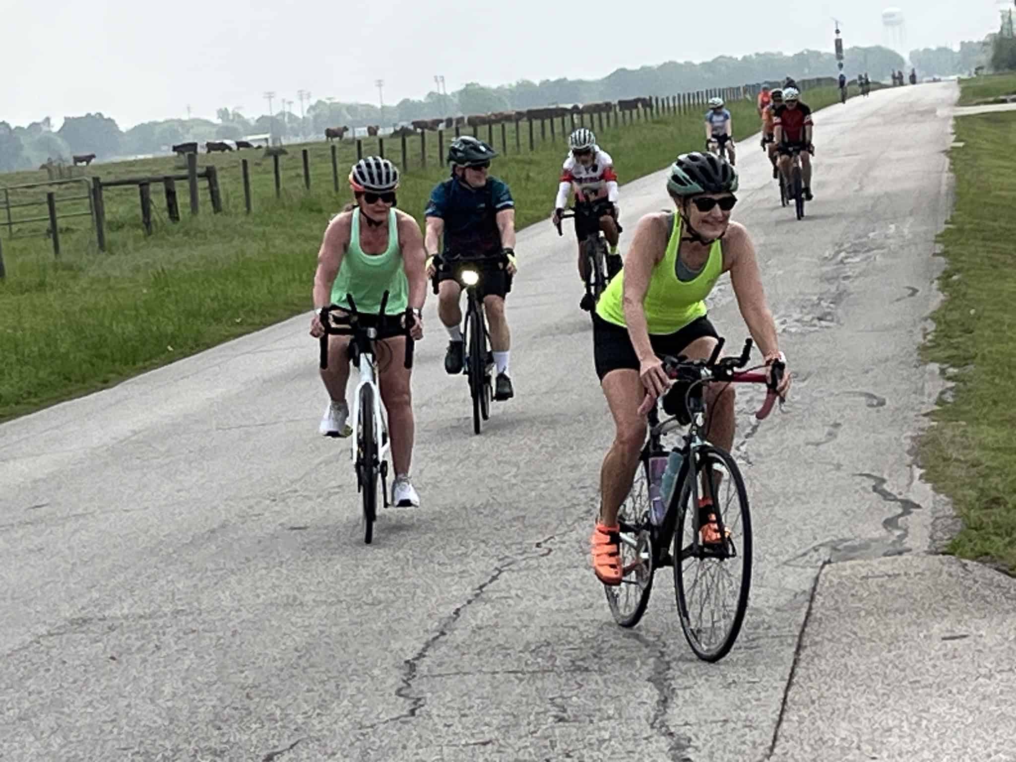 Cyclists riding on a scenic countryside road, enjoying outdoor biking adventure.
