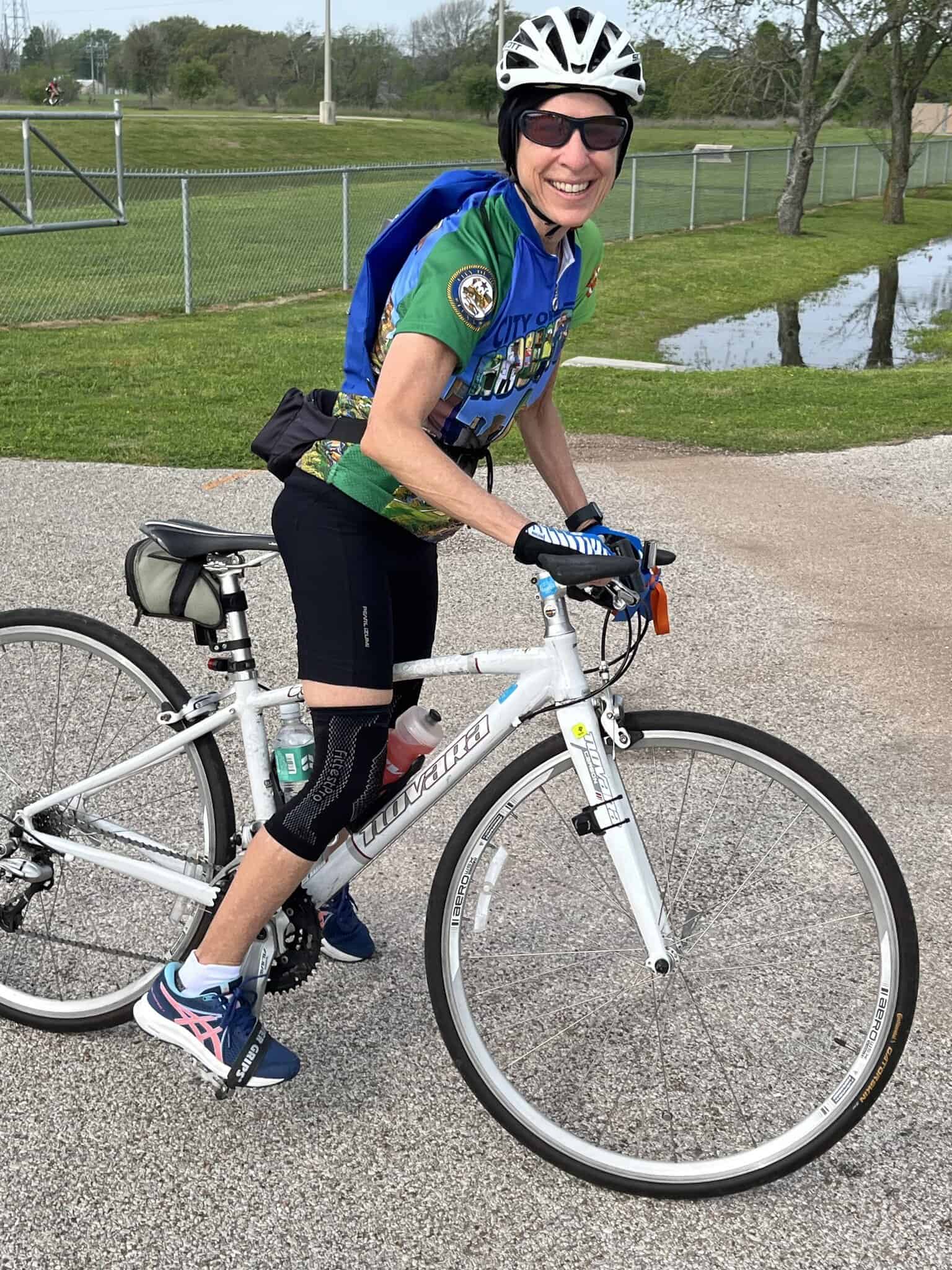 Comfortable woman enjoying a bike ride with her bike on a trail, promoting Bluebonnet Express cycling events.