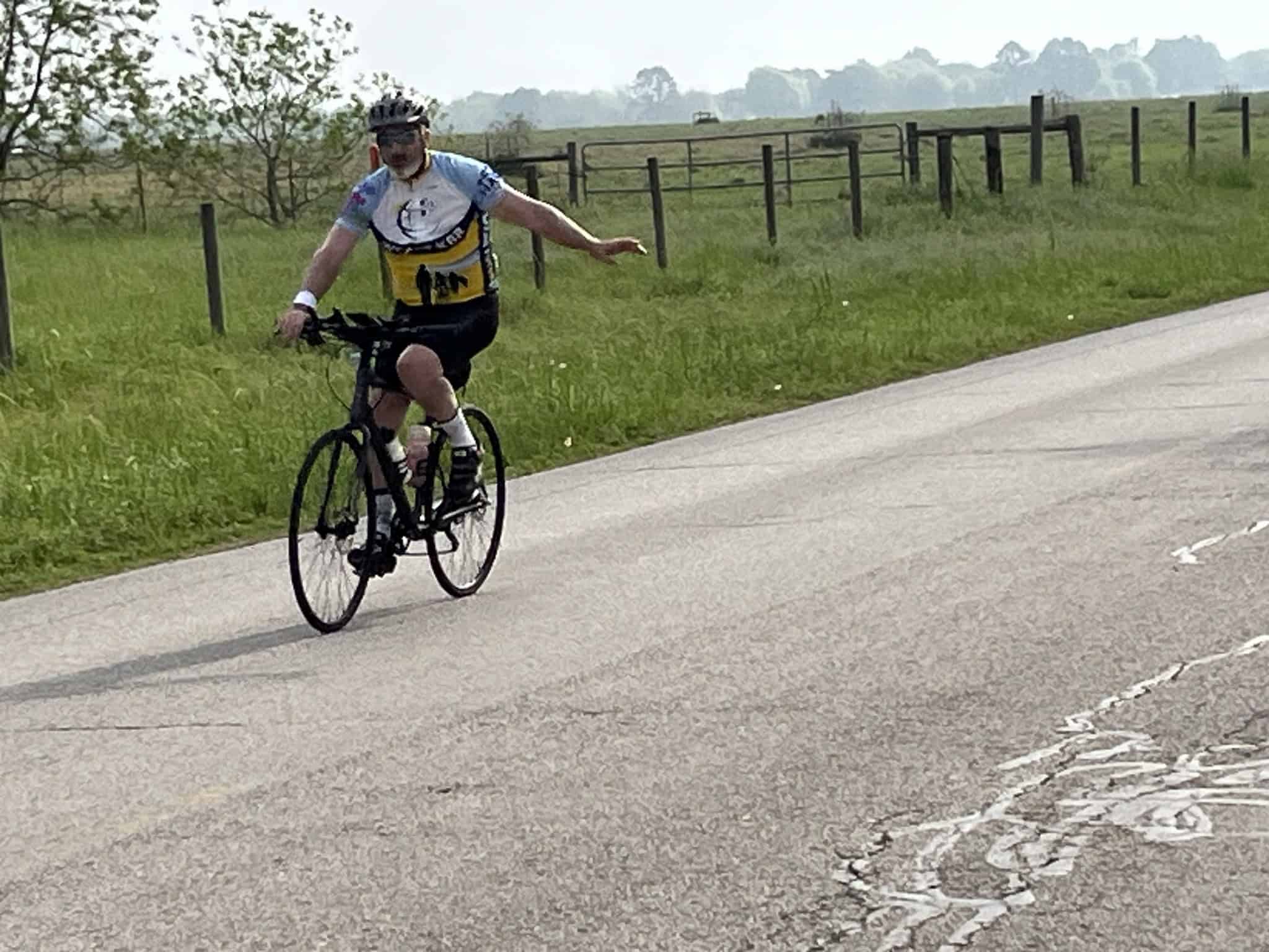 Bike rider on scenic countryside road, promoting Bluebonnet Express cycling tours.