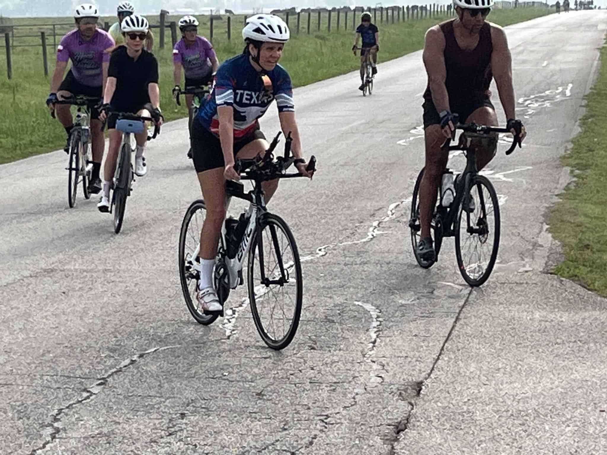 Cyclists riding on a scenic rural road during daytime, part of Bluebonnet Express bike event.