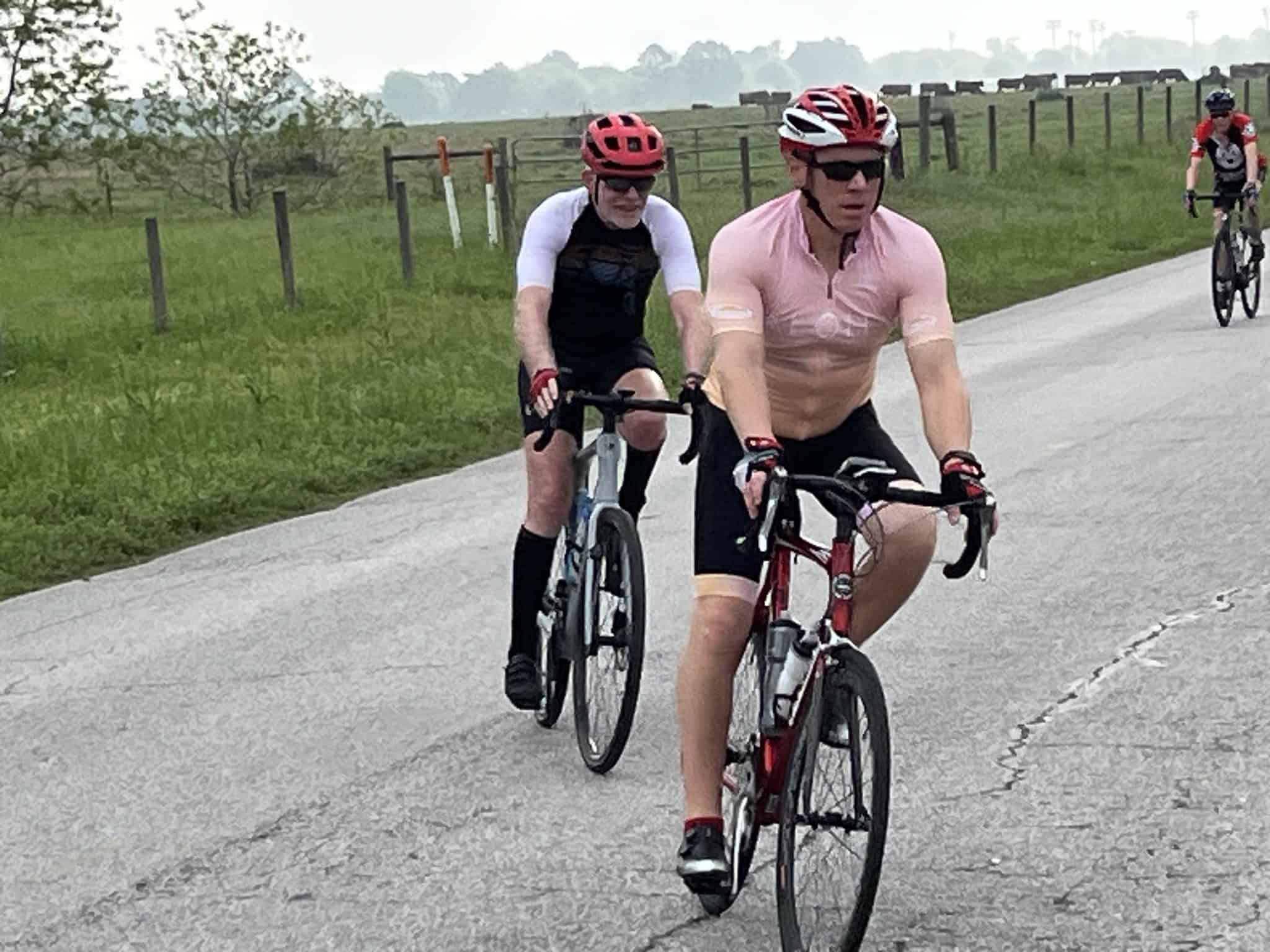 Cyclists riding on a rural road, enjoying the scenic Bluebonnet Express route for bike enthusiasts.