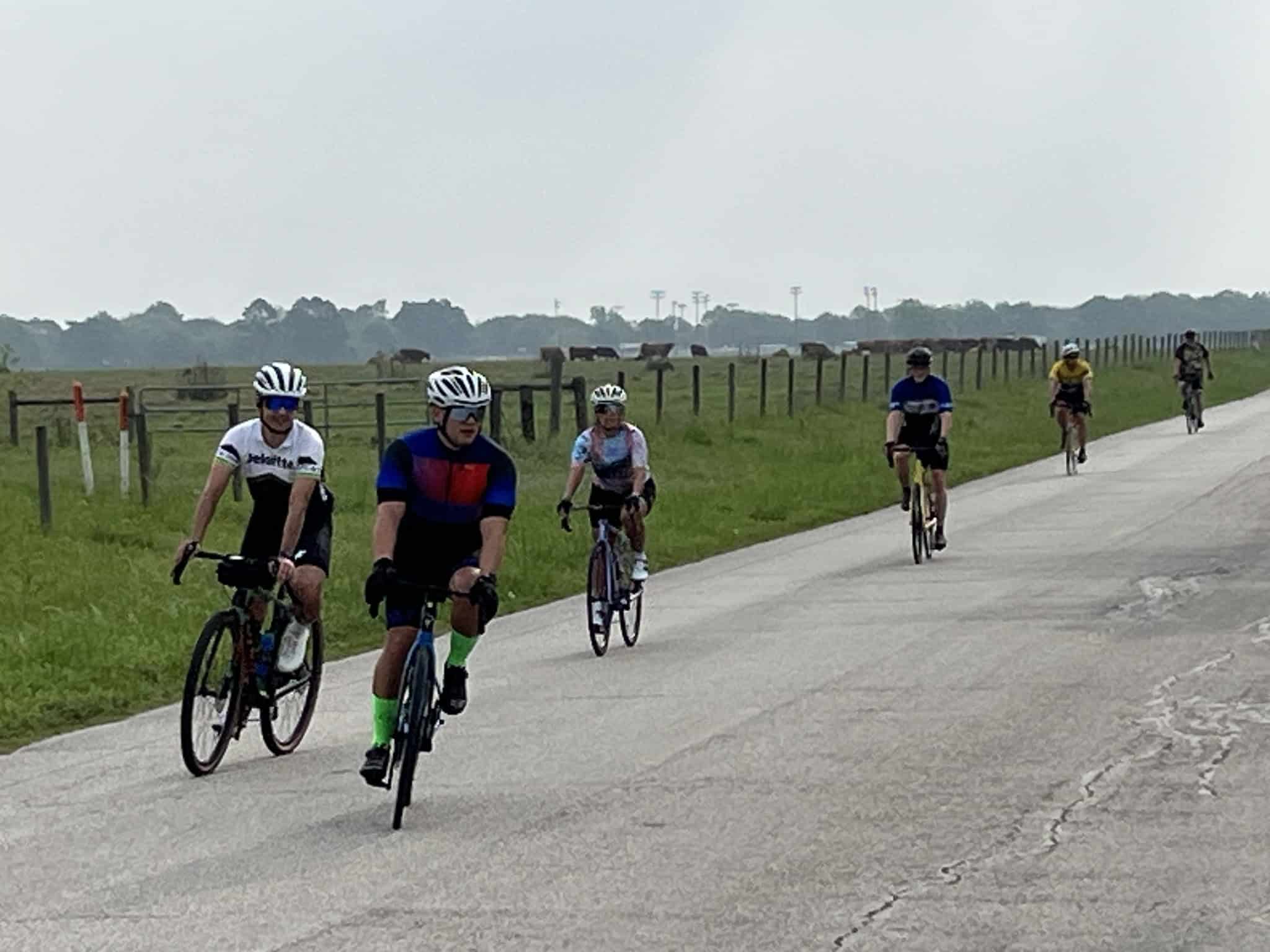 Cyclists riding on a scenic rural road, promoting Bluebonnet Express bike tours and outdoor cycling adventures.