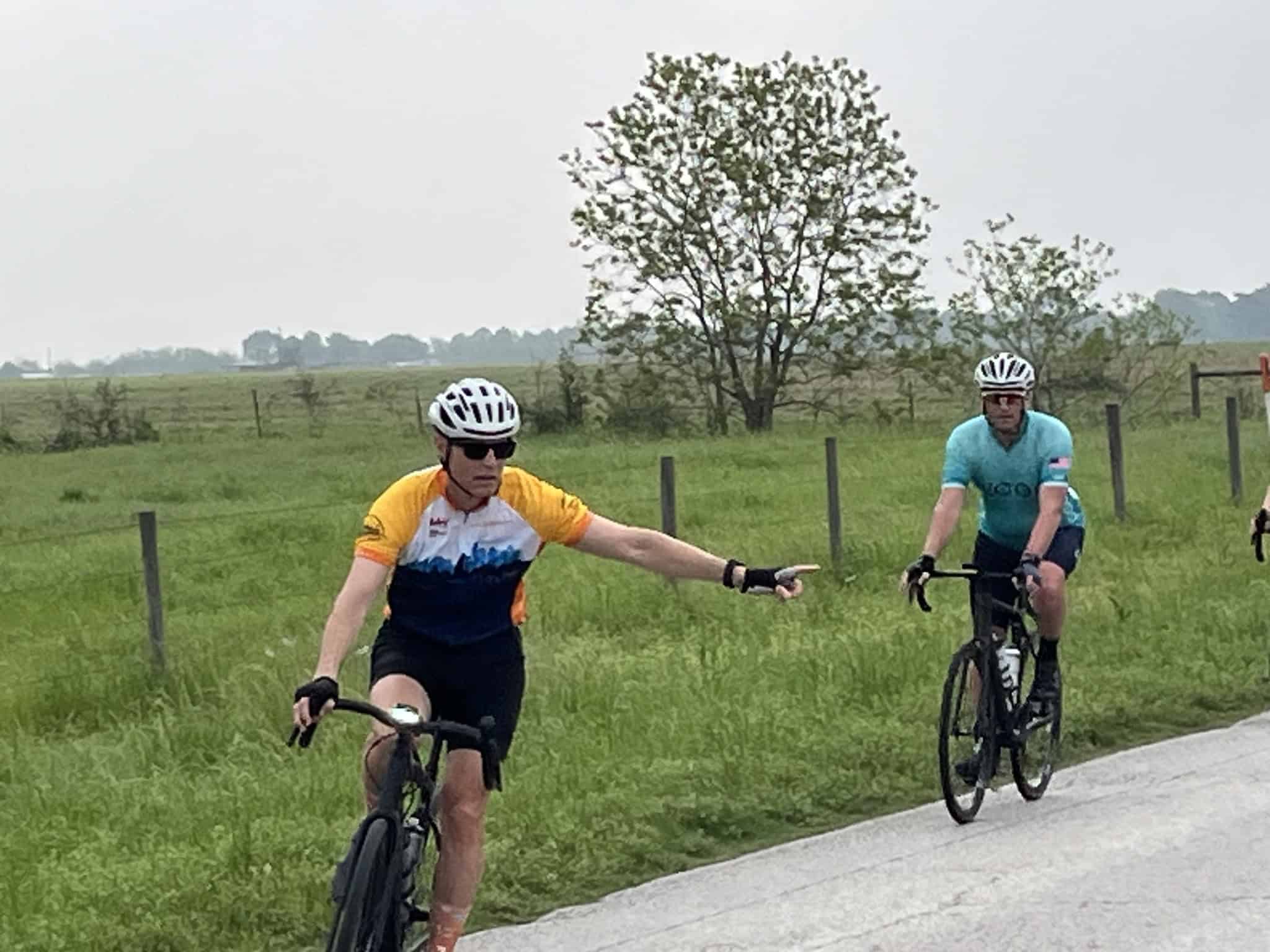 Brightly dressed cyclists riding on a rural bike path in Texas, promoting Bluebonnet Express cycling tours.