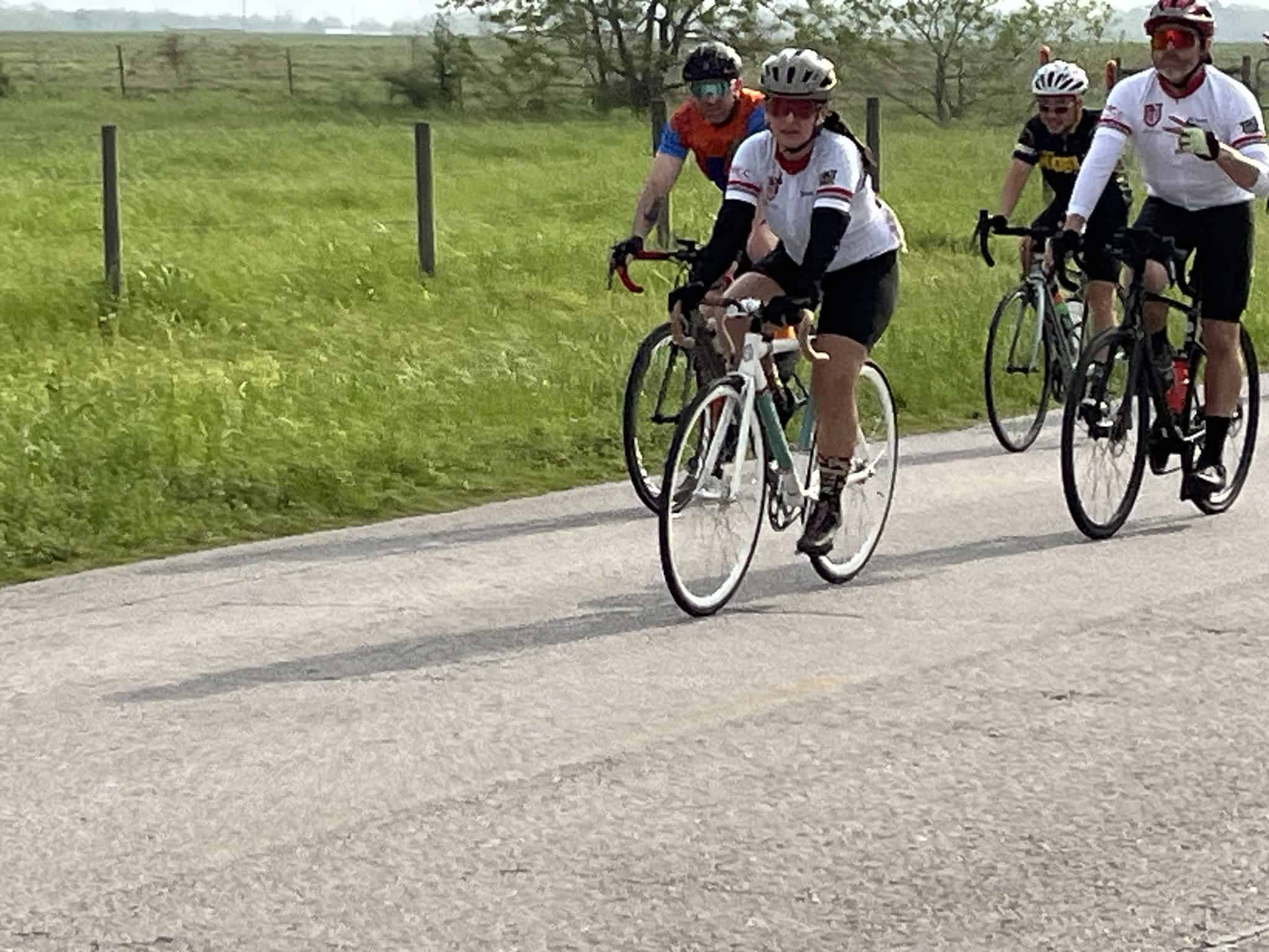 Cyclists on a scenic rural road enjoying a group bike ride during daytime.
